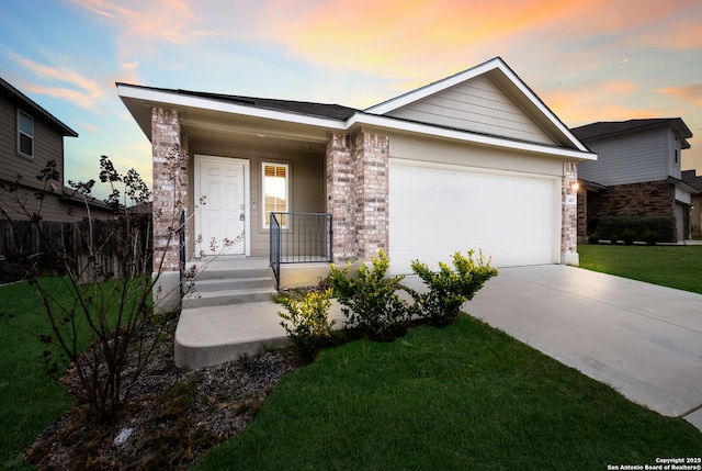 single story home with covered porch, a yard, driveway, and a garage