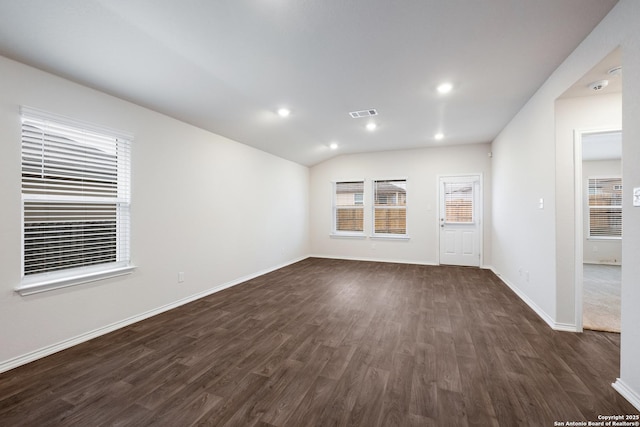 spare room with lofted ceiling, recessed lighting, dark wood-type flooring, visible vents, and baseboards