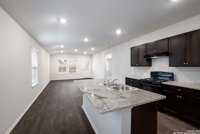 kitchen featuring black gas range, under cabinet range hood, dark wood-style floors, and a sink