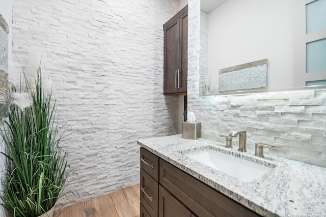 bathroom featuring tasteful backsplash, wood finished floors, and vanity