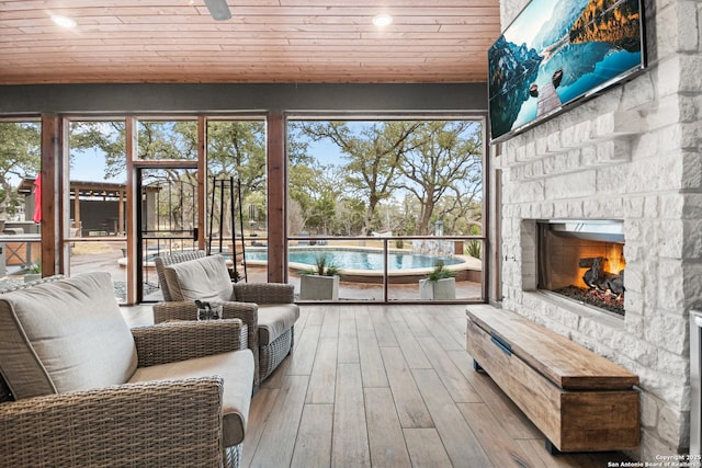 sunroom featuring a fireplace and wood ceiling