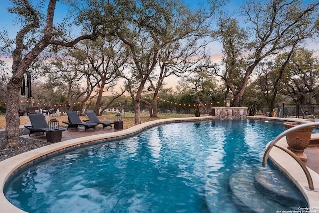 pool with a patio area and fence