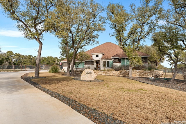 view of front of house featuring a front lawn and fence