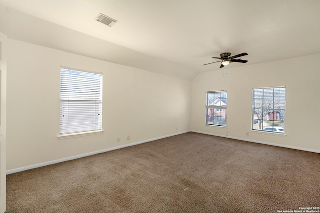 empty room featuring baseboards, visible vents, a ceiling fan, lofted ceiling, and carpet flooring