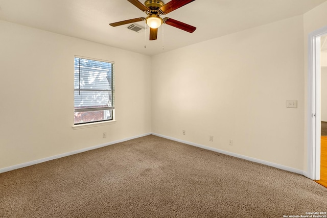 carpeted spare room featuring baseboards, visible vents, and a ceiling fan