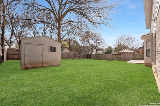 view of yard featuring a storage unit, an outdoor structure, and a fenced backyard