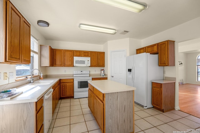 kitchen with white appliances, visible vents, light countertops, and a sink