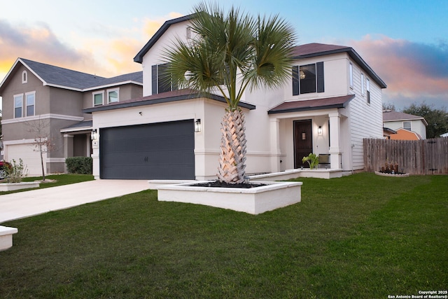 view of front facade with a garage, fence, concrete driveway, stucco siding, and a front lawn