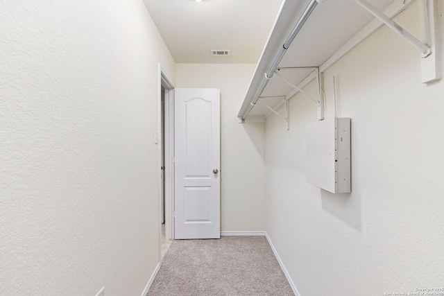 walk in closet featuring visible vents and light colored carpet