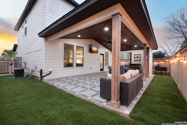 rear view of property featuring ceiling fan, central AC unit, a lawn, and a fenced backyard