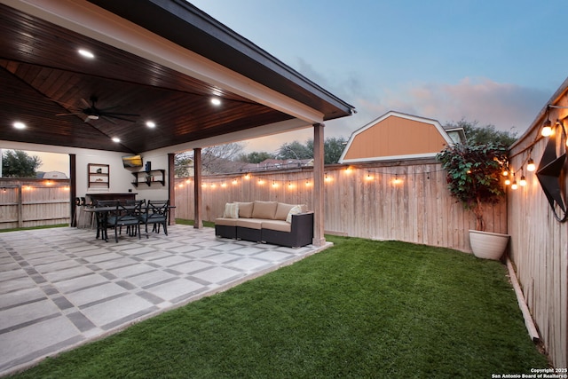 view of yard featuring a patio, outdoor dining area, a fenced backyard, an outdoor hangout area, and a ceiling fan