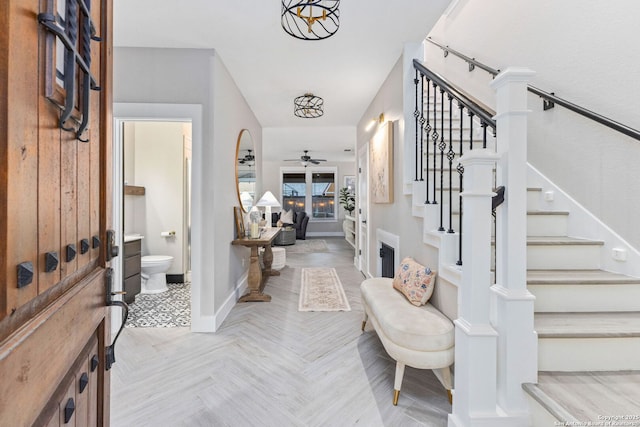 entryway with stairs, baseboards, and a ceiling fan