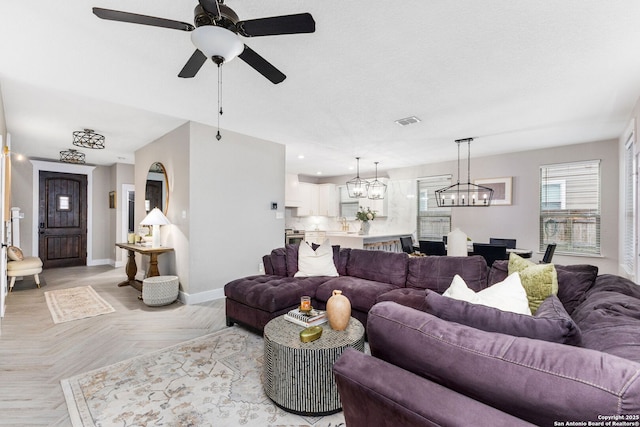 living area with recessed lighting, visible vents, baseboards, and ceiling fan with notable chandelier