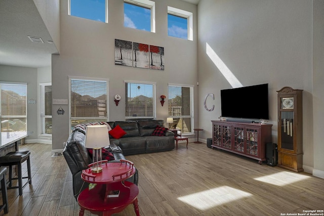 living area featuring wood finished floors, visible vents, and baseboards