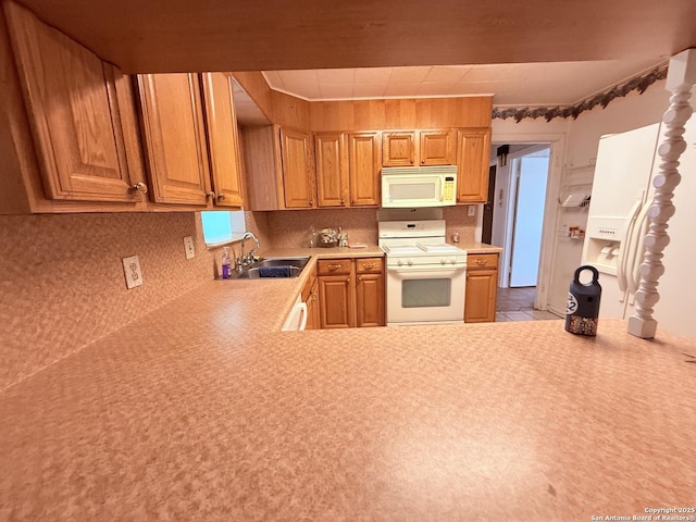 kitchen featuring white appliances, light countertops, a sink, and backsplash