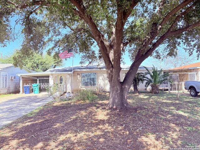 single story home featuring concrete driveway and fence