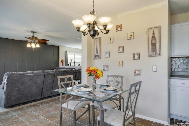 dining room with baseboards and ceiling fan with notable chandelier