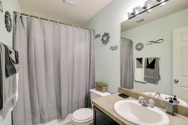 bathroom featuring toilet, a textured wall, vanity, and visible vents