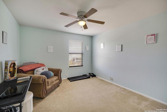 sitting room with ceiling fan, baseboards, and light colored carpet