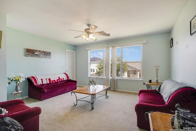 living area with carpet flooring, ceiling fan, and baseboards