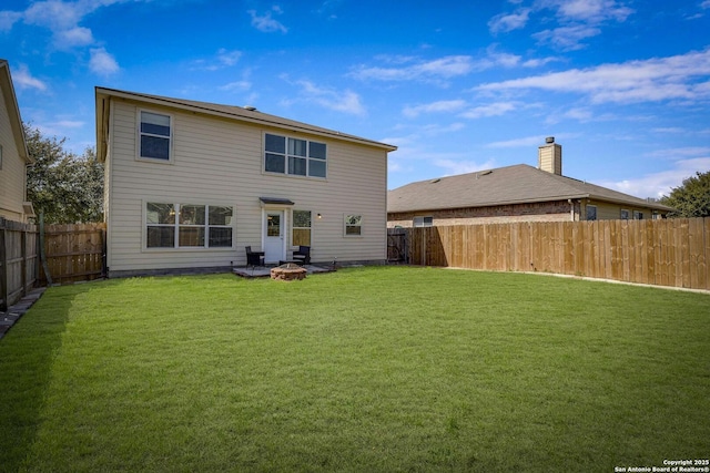 back of property featuring a fenced backyard, a fire pit, and a lawn