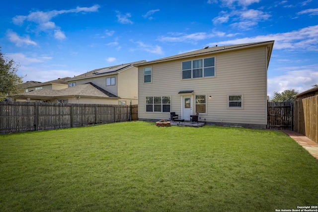 back of house with a patio area, an outdoor fire pit, a fenced backyard, and a yard