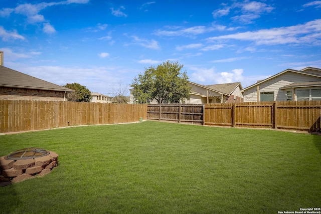 view of yard featuring an outdoor fire pit and a fenced backyard