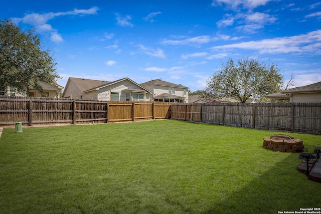 view of yard with an outdoor fire pit and a fenced backyard