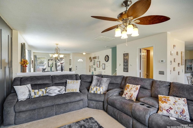 carpeted living area with visible vents and ceiling fan with notable chandelier