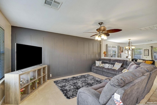 carpeted living area featuring visible vents and ceiling fan with notable chandelier