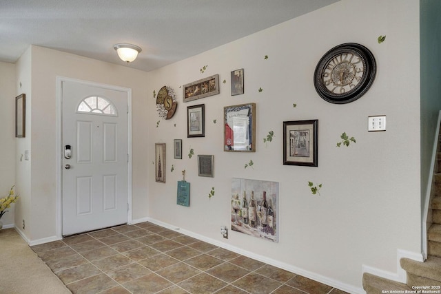 tiled entrance foyer with stairs and baseboards