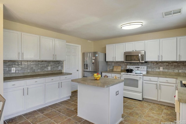 kitchen featuring a kitchen island, visible vents, white cabinetry, appliances with stainless steel finishes, and tasteful backsplash