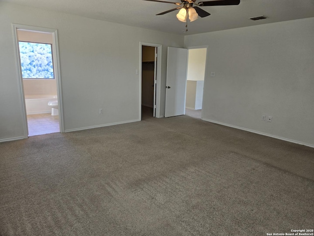 empty room with a ceiling fan, carpet flooring, visible vents, and baseboards