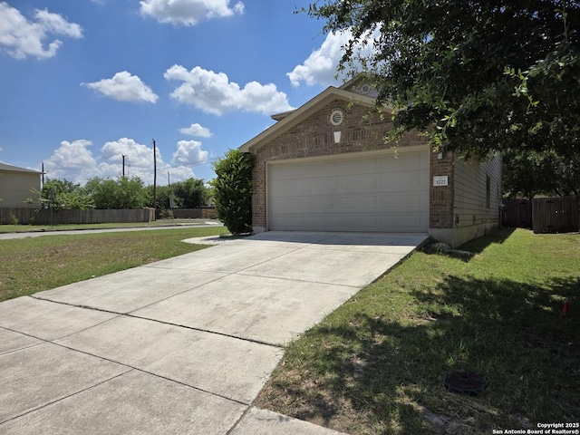 view of front of house with brick siding, concrete driveway, an attached garage, a front yard, and fence