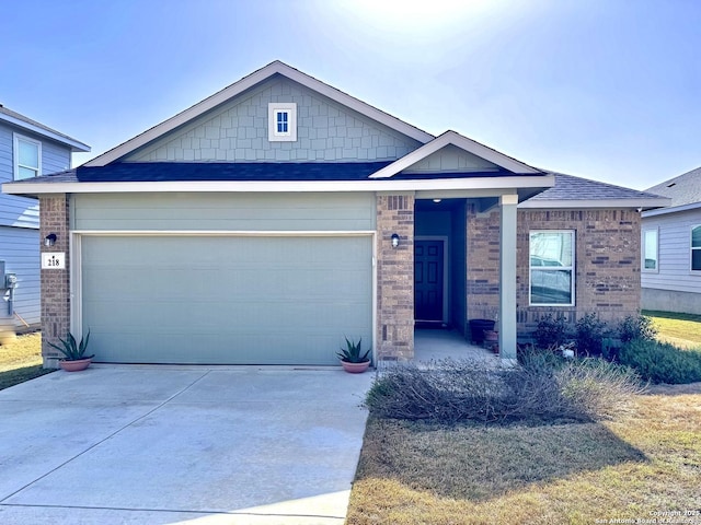 view of front facade featuring a garage, concrete driveway, brick siding, and a shingled roof