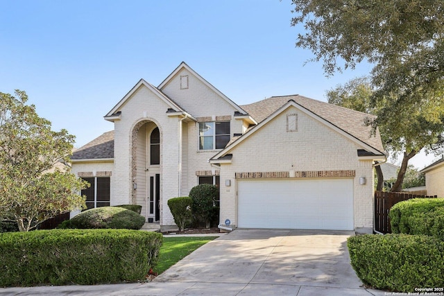 traditional home featuring a garage, concrete driveway, brick siding, and a shingled roof