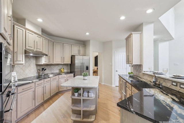 kitchen with open shelves, appliances with stainless steel finishes, light wood-style floors, a sink, and under cabinet range hood