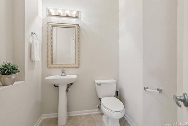 bathroom with toilet, tile patterned flooring, and baseboards