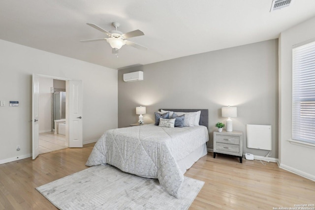 bedroom with multiple windows, a wall mounted AC, visible vents, and light wood-style floors