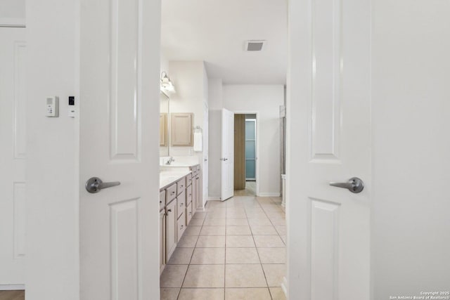 full bathroom featuring double vanity, baseboards, visible vents, tile patterned floors, and a sink