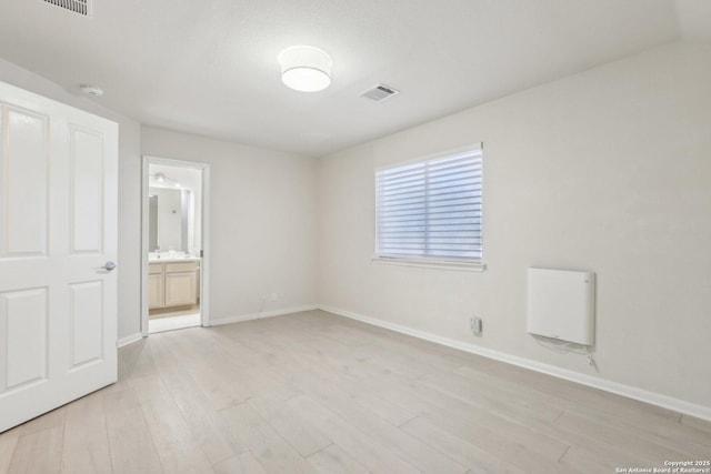 unfurnished bedroom with light wood-type flooring, visible vents, and baseboards