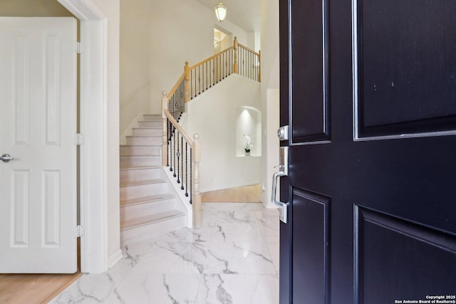 entryway featuring stairs and marble finish floor