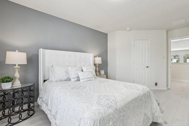 bedroom with light wood-style flooring and baseboards