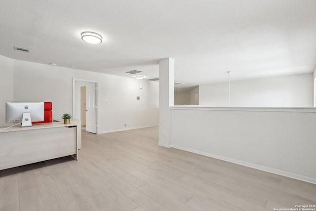 empty room featuring baseboards, visible vents, and light wood finished floors