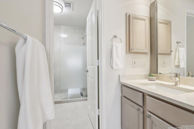 bathroom with a stall shower, vanity, and visible vents