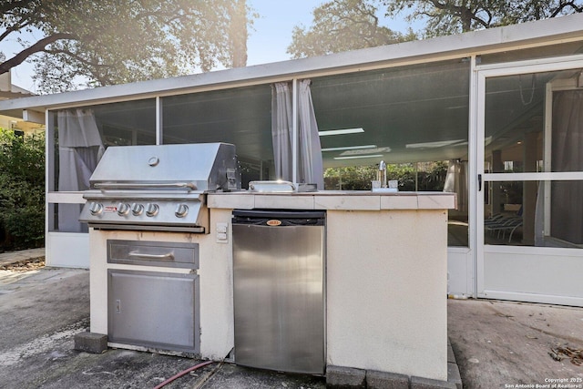 view of patio / terrace featuring exterior kitchen, area for grilling, and a sunroom