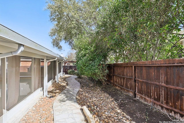 view of yard featuring a fenced backyard and a sunroom