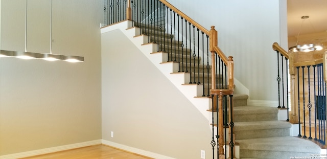 staircase featuring baseboards and wood finished floors