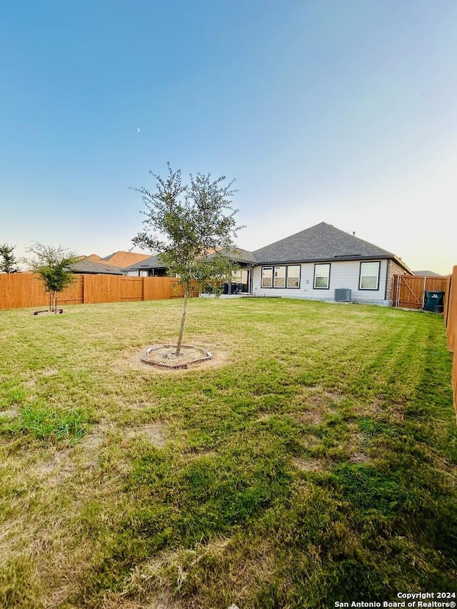 view of yard with cooling unit and a fenced backyard