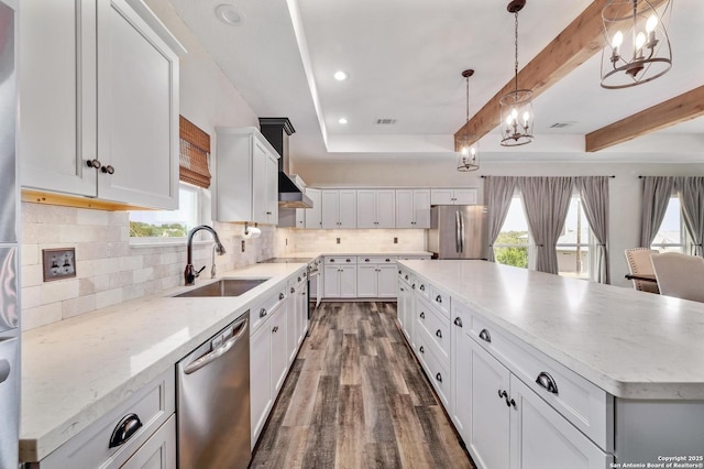 kitchen featuring dark wood-style floors, beam ceiling, backsplash, appliances with stainless steel finishes, and a sink